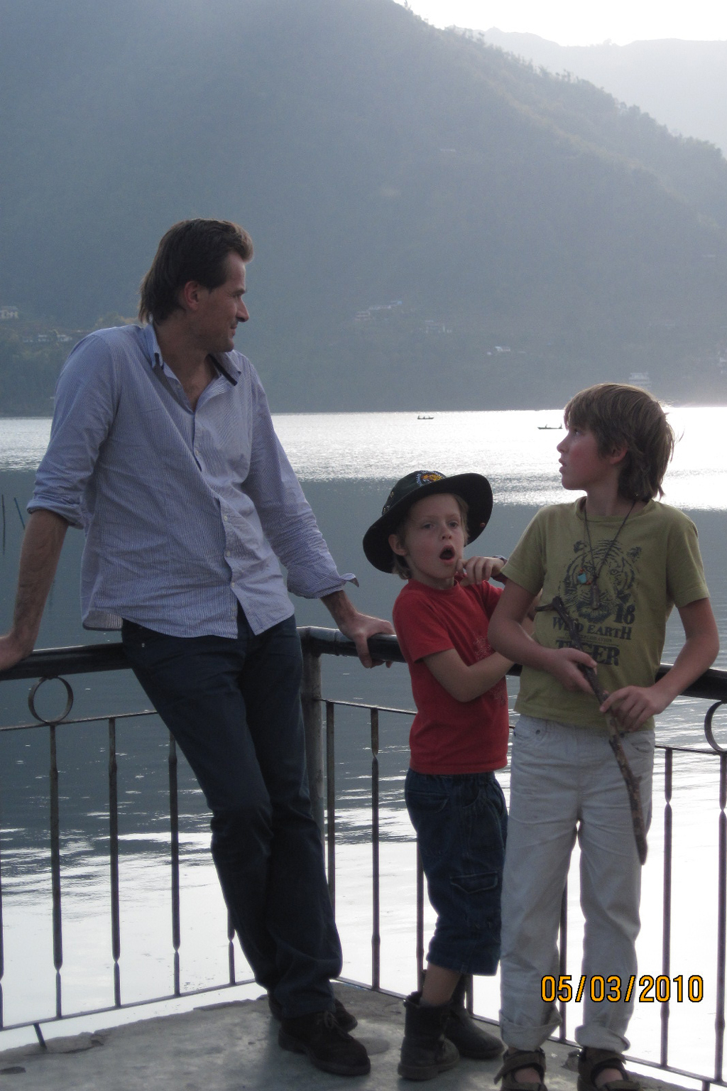 Un homme avec ses 2 enfants au bord d'un lac