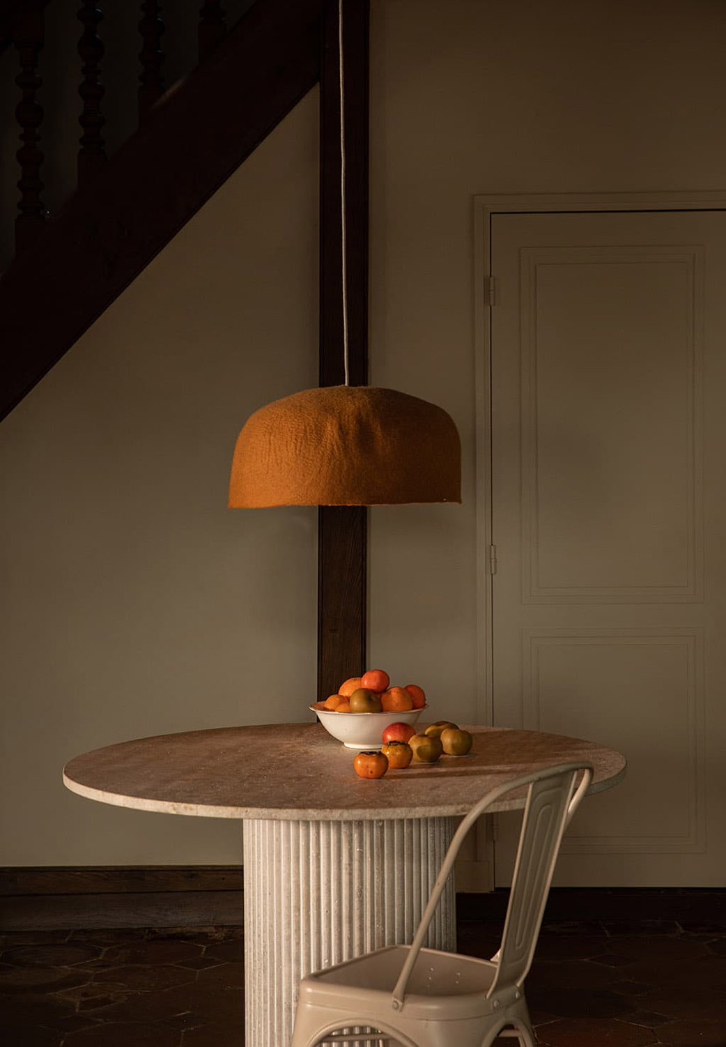 Organischer orangefarbener Lampenschirm aus Wollfilz über einem Esstisch