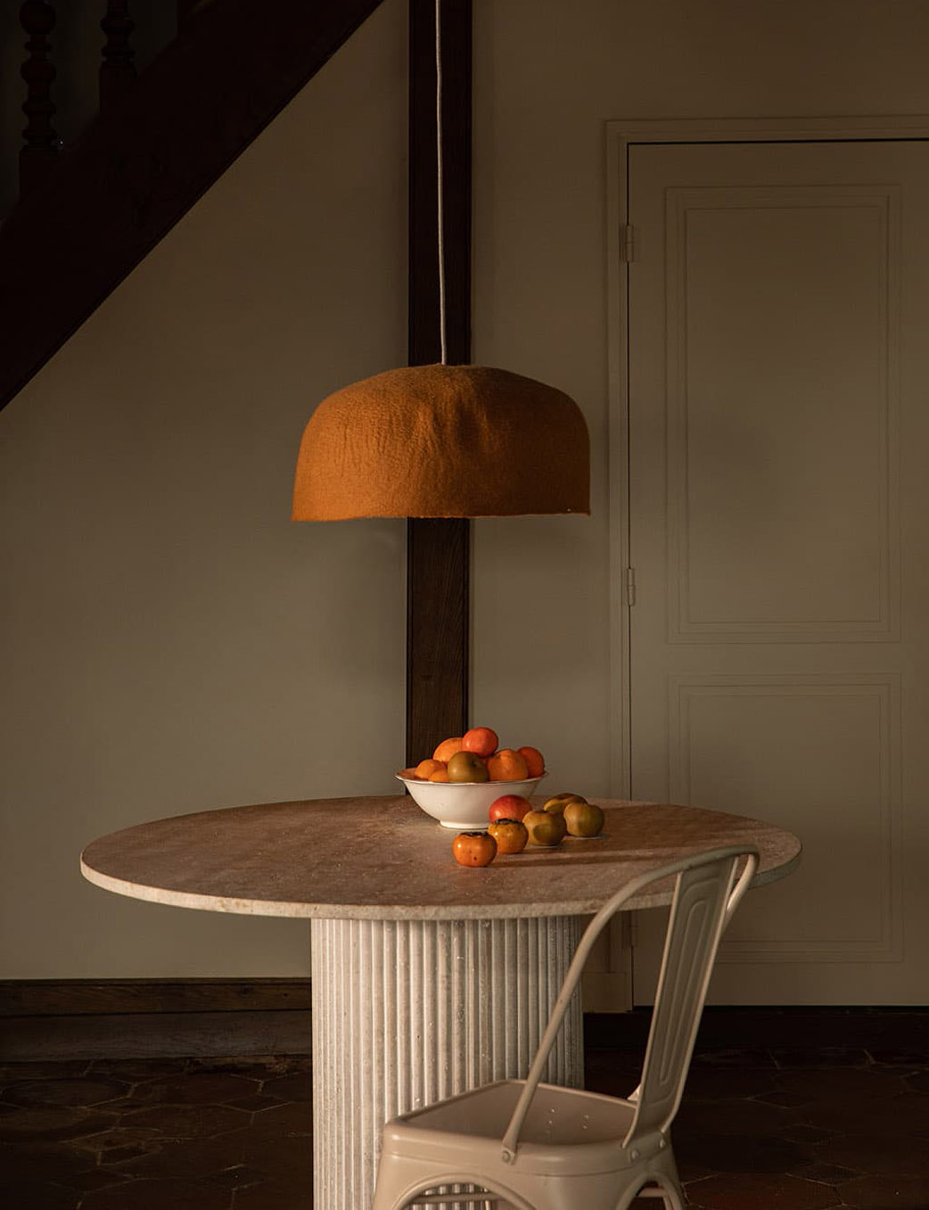 Organic orange wool felt lampshade above a dining table