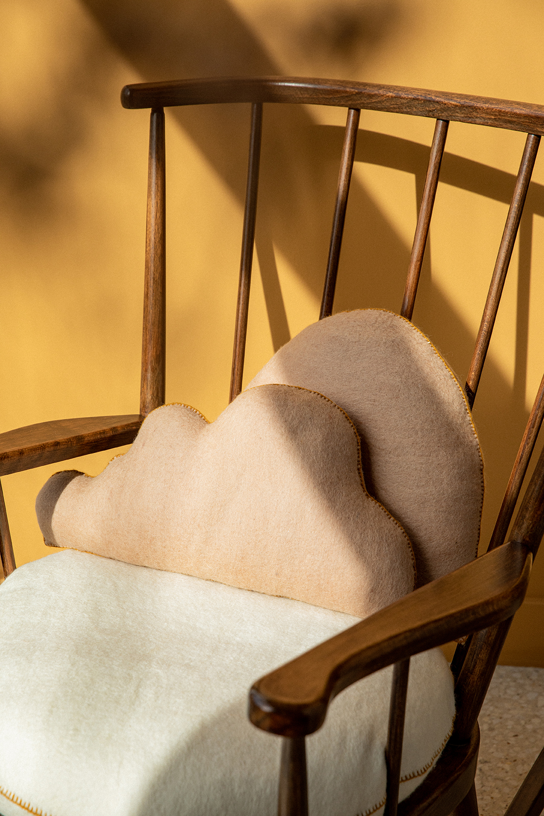 Duo de coussins en feutre de laine sur un rocking chair