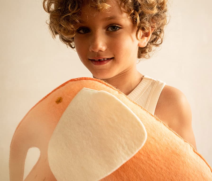 Pink elephant-shaped cushion made of felted wool to decorate a child’s bedroom