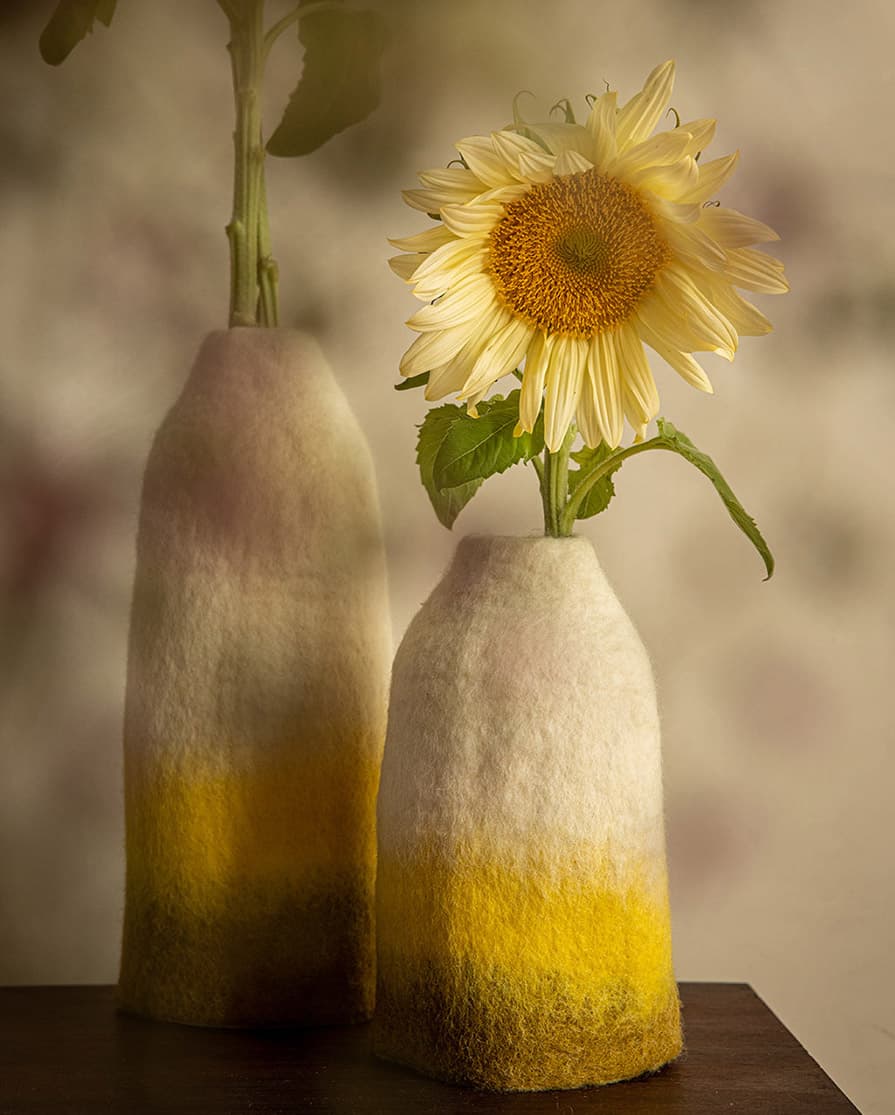 Set of two wool vase covers in shades of green and yellow to decorate a wooden coffee table
