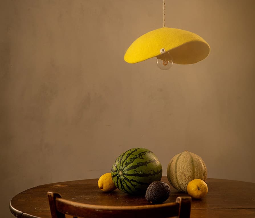 Abat-jour minimaliste jaune citron en laine au-dessus d’une table en bois