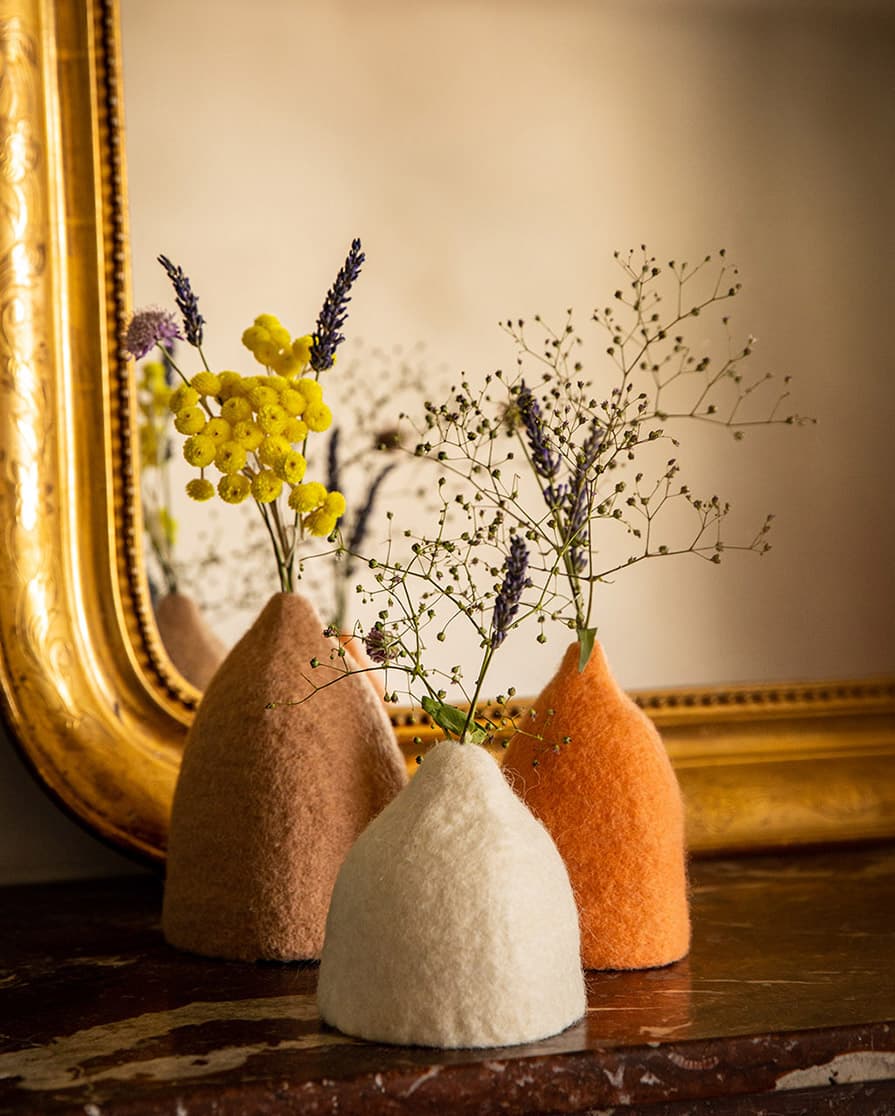 Trio de soliflores rose clair, blanc et pêche en laine feutrée pour décorer un rebord de cheminée en marbre