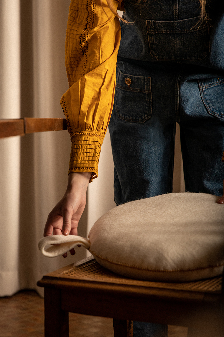 White round cushion with a handle placed on a chair