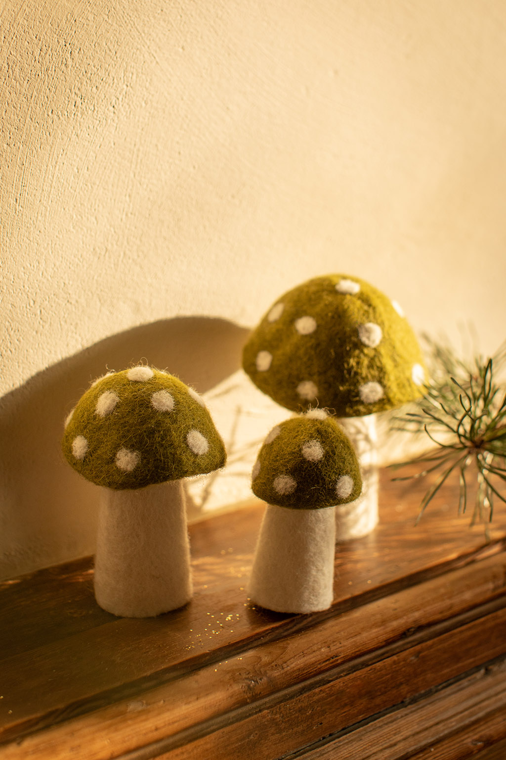 Trio de petits champignons décoratifs à pois sur le rebord d’une cheminée