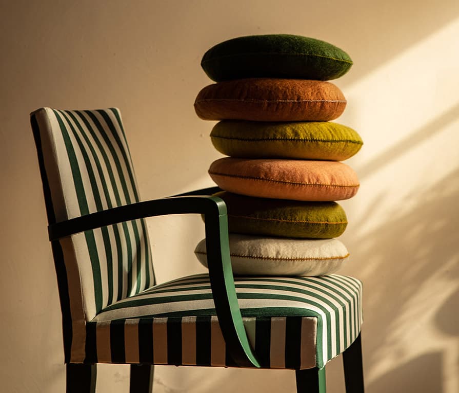 Stack of small round felt cushions to decorate an armchair