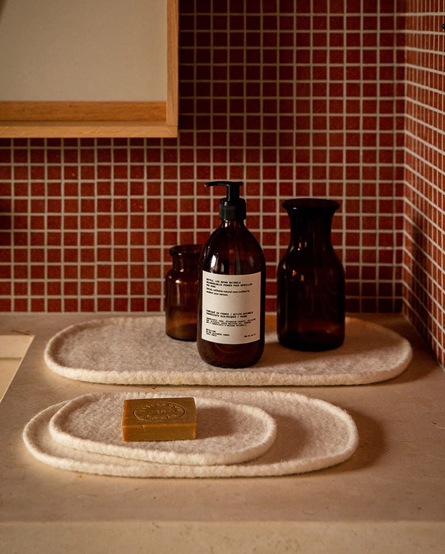 Trio of white decorative wool felt trays in a bathroom