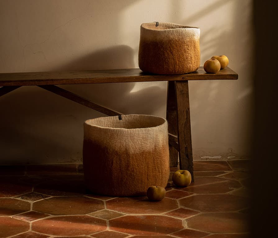 Duo of two-tone orange and white felted wool storage baskets