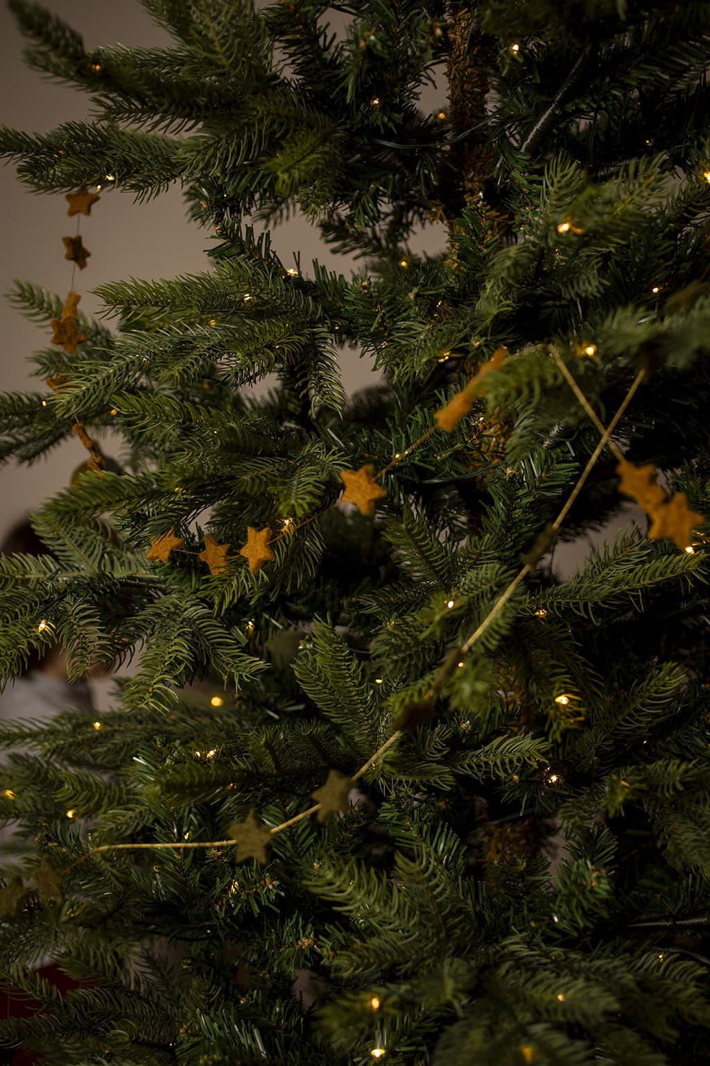 Okerkleurige kerstslinger met kleine wollen sterren