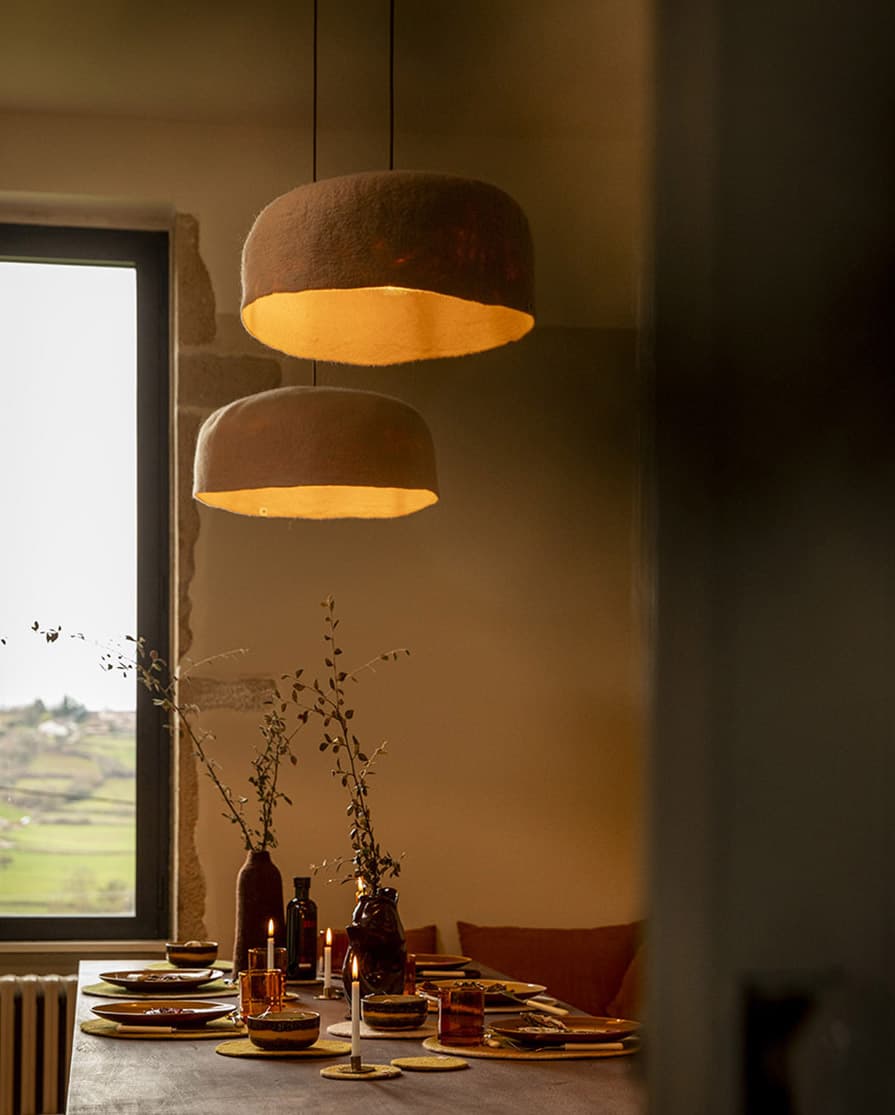 Abat-jours en laine rose à suspendre au-dessus d’une table à manger en bois