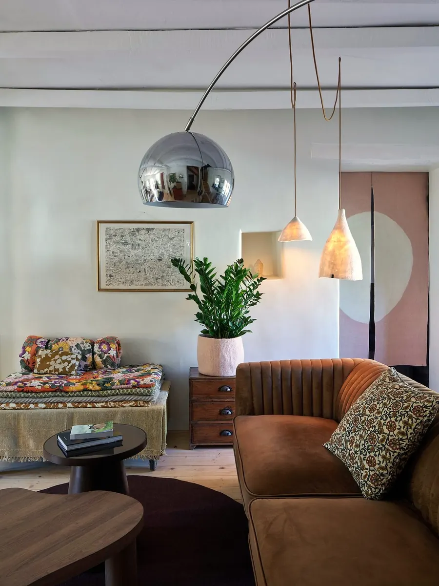 Wohnzimmer mit Samtsofa und Bogenlampe