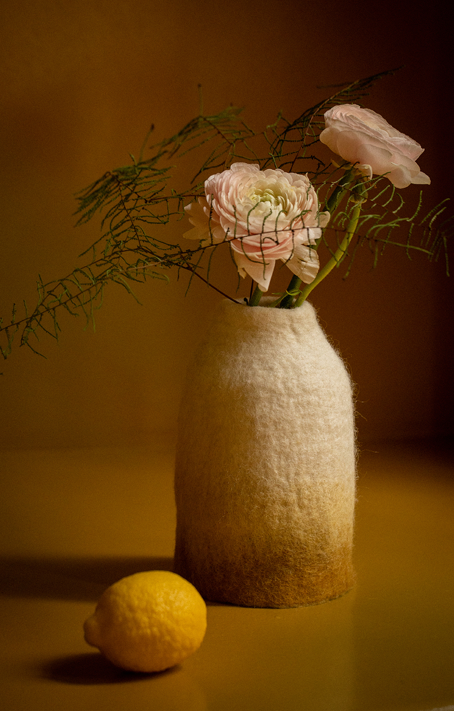 Un cache-vase jaune et blanc en feutre avec 3 fleurs